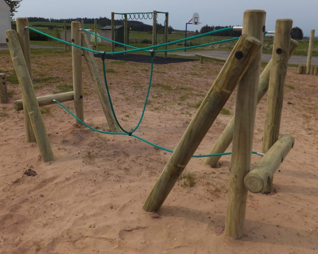 wooden trim trail item Burma Bridge installed onto play sand