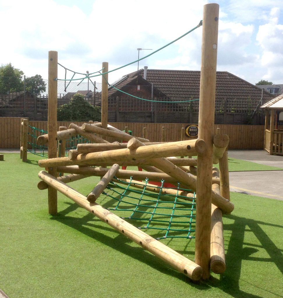 a timber climbing frame installed onto artificial grass