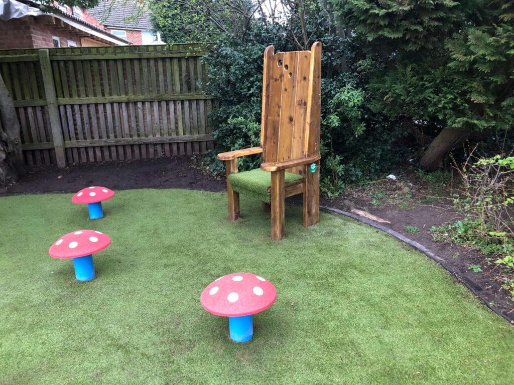 rubber red toadstool mushroom seats and wooden storytelling chair with artificial grass