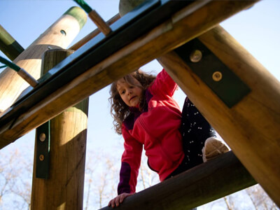 Child climbing active play equipment