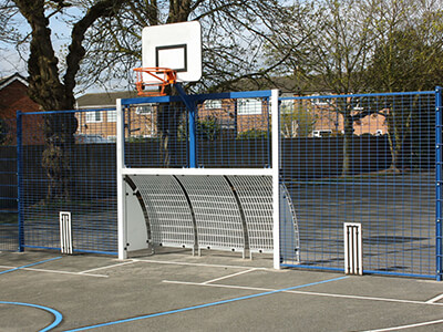 Outdoor multi-use gym area (MUGA) with basketball net, football or hockey goal, play markings, cricket wicket targets and fence