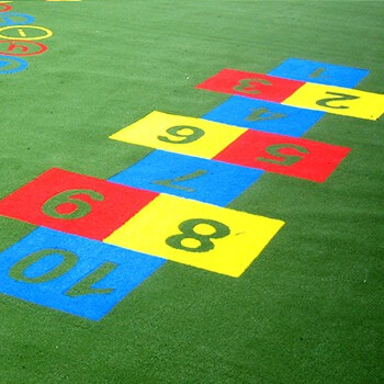 Colourful hopscotch playground markings on green play carpet