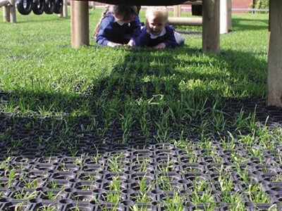 rubber grass mat underneath play equipment with children crawling