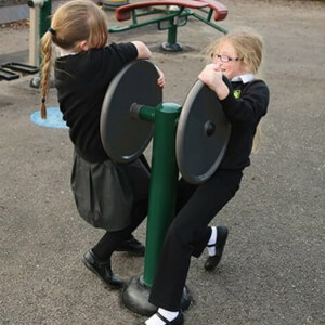 Two children using Double Strength Challenge equipment from The School Playground Company, each pulling a dark-coloured wheel in opposite directions