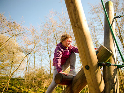 A child climbing on wooden playground climbing equipment