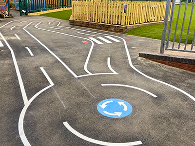 Playground markings in race track and roundabout design in white thermoplastic