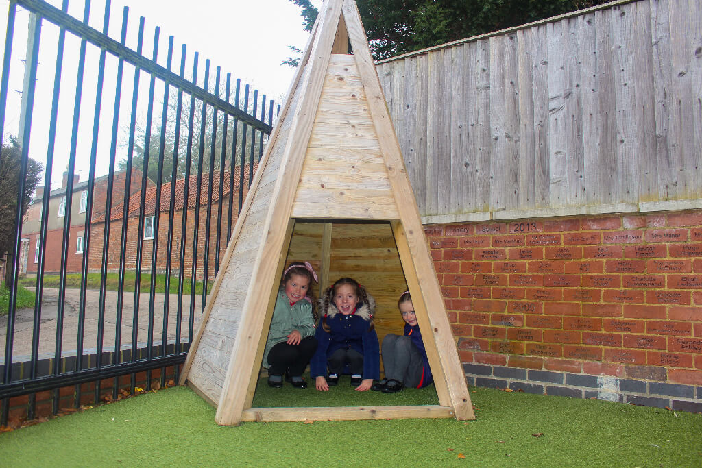 children in a wooden playground teepee