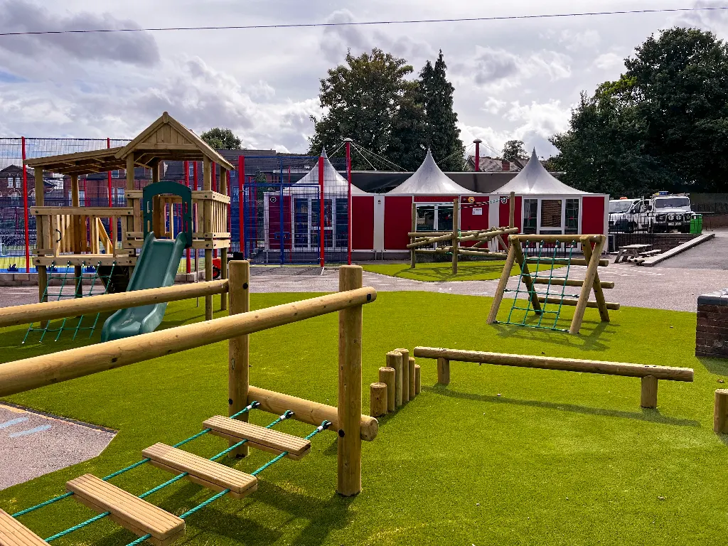 A playground with a variety of wooden play equipment