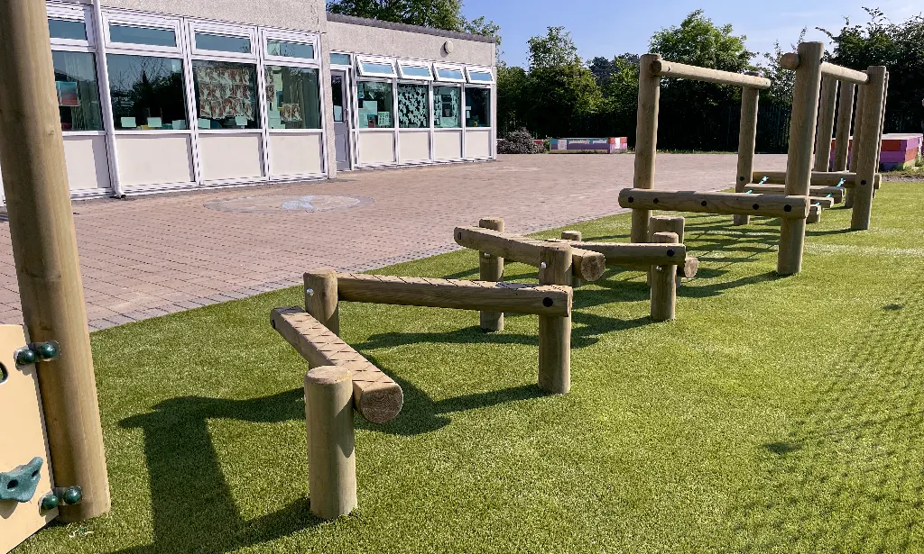 Timber trim trail with balance beams and rope bridge