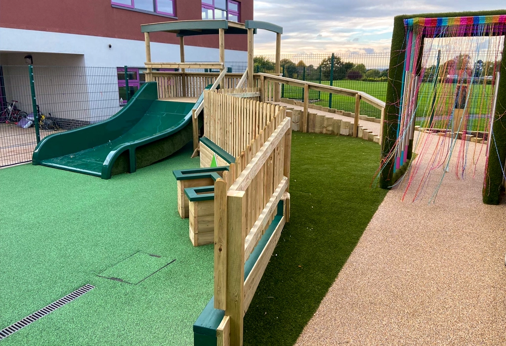 Large bespoke playground with sensory archway over a path, accessible walkway and a large playground slide in a Nottinghamshire school playground
