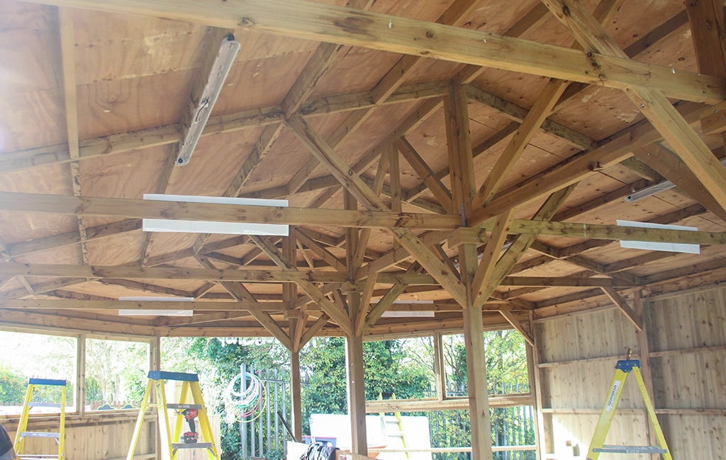 wooden interior of large gazebo roof with wooden cross beams