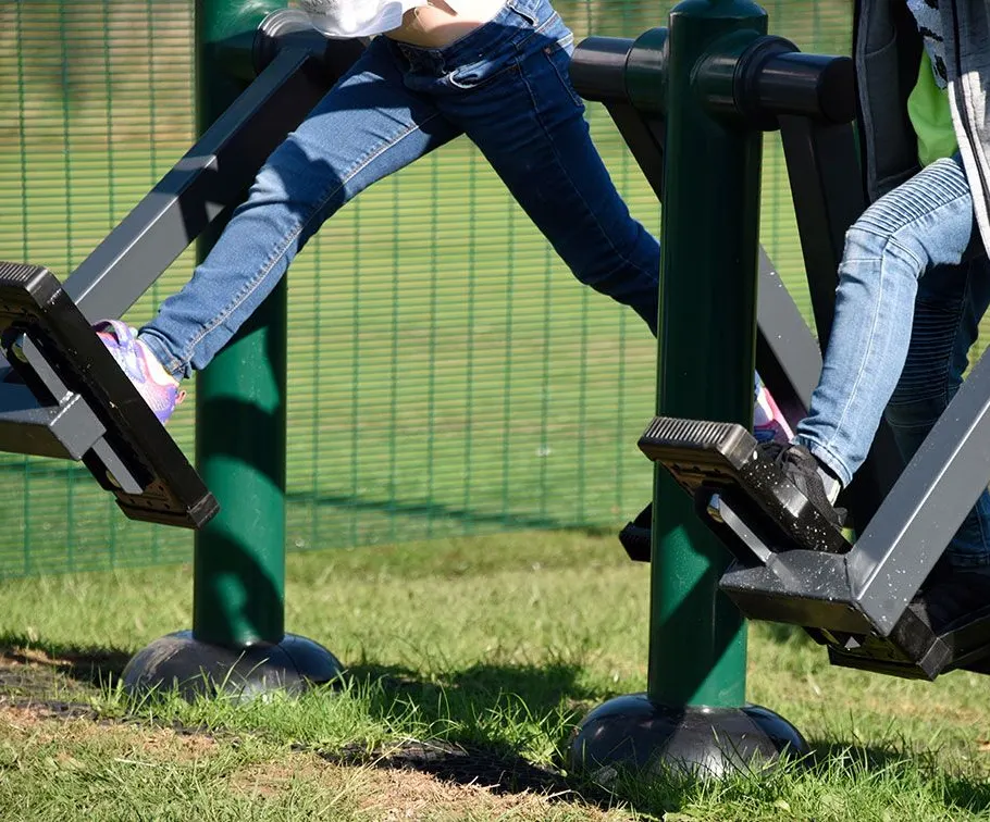 2 children using double health walker outdoor gym equipment