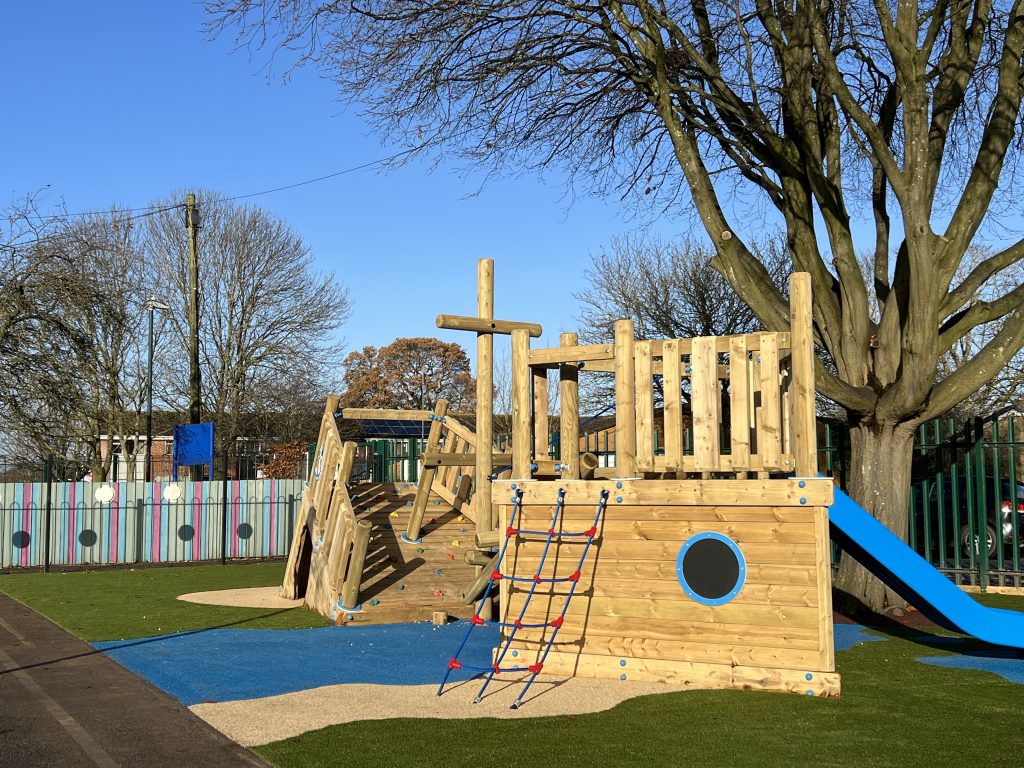 Wooden playground structure in the style of a shipwrecked pirate ship