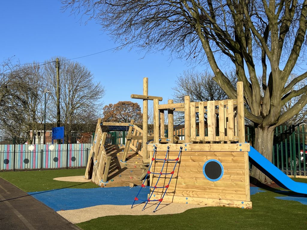Wooden playground structure in the style of a shipwrecked pirate ship