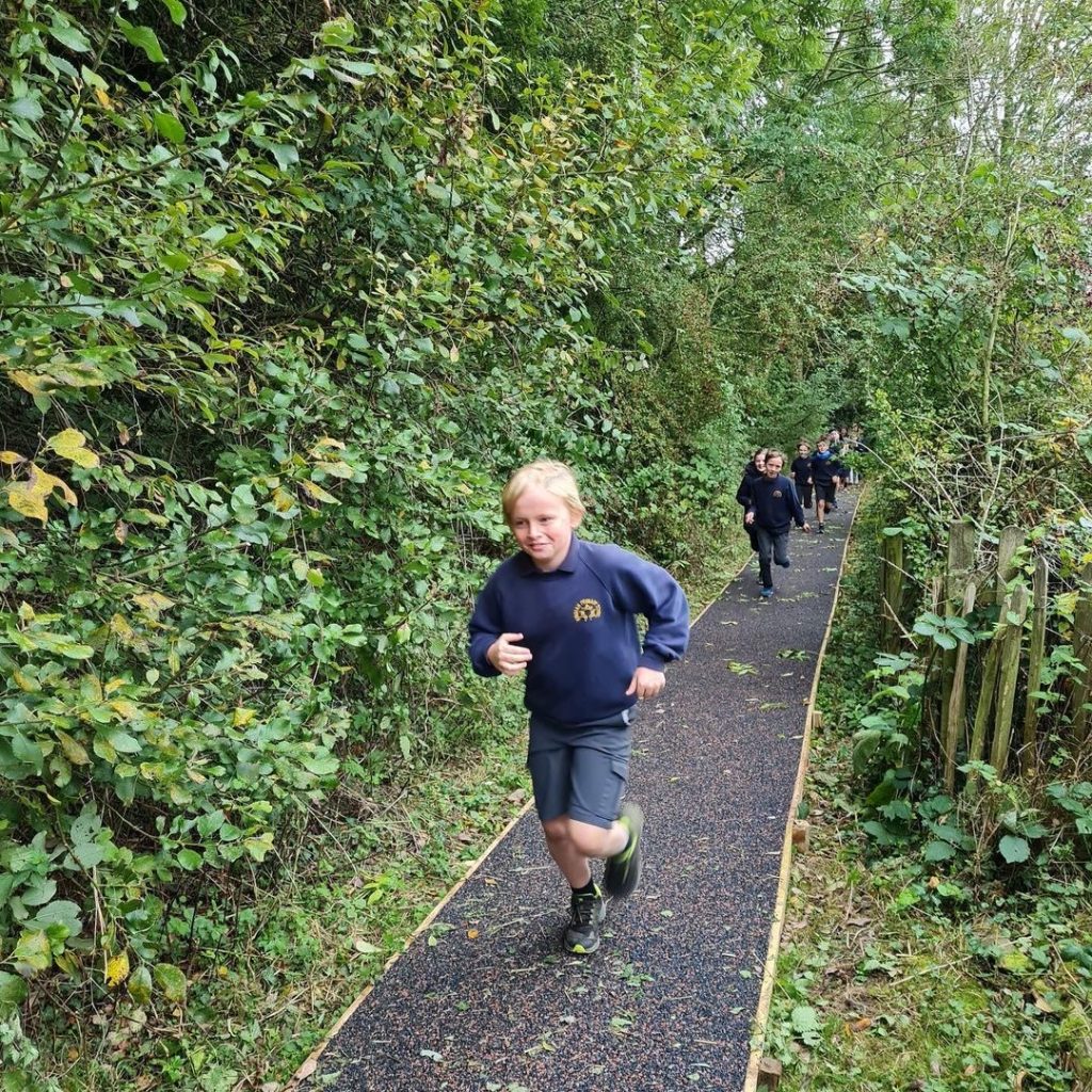 Children Running on Conipave daily mile track through a woodedn area