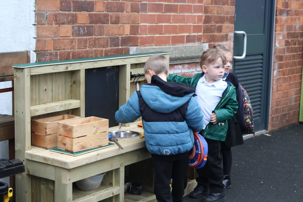 Children playing together with the messy play kitchen