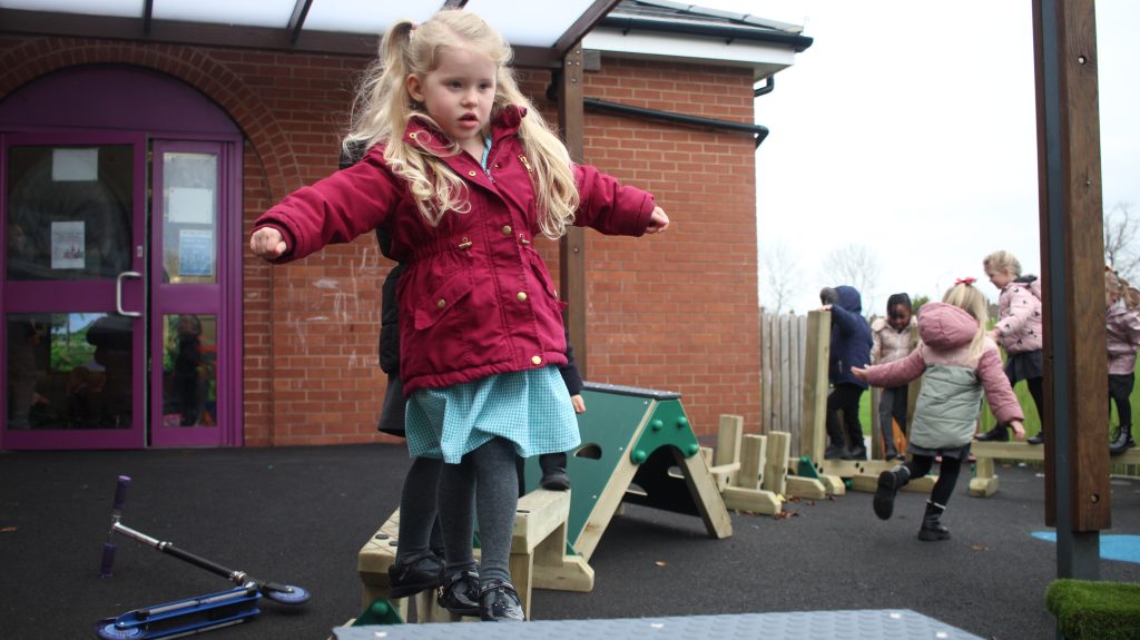 EYFS child on Trim Trail balance beam from School Playground Company's Active Play range, available from the playground equipment shop.