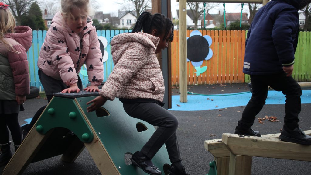 EYFS child using A Frame Climbing Wall from School Playground Company's Trim Trail Range.