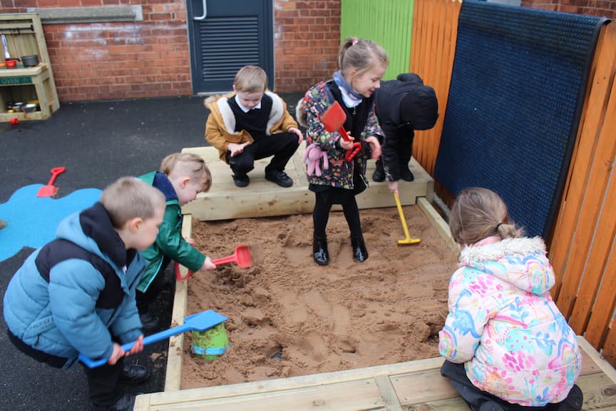 Six EYFS Children using Sand Pit
