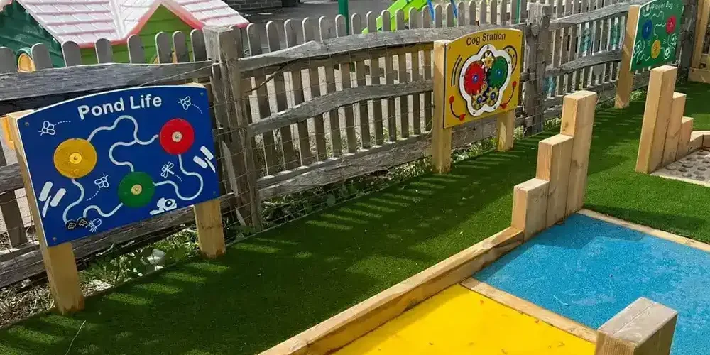 Sensory play panels mounted on playground fence