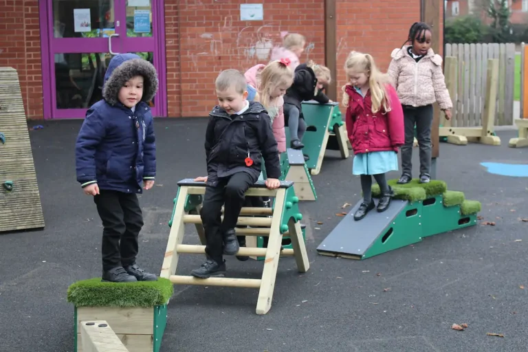 Children clambering over the A Frame ladder and platform ramp
