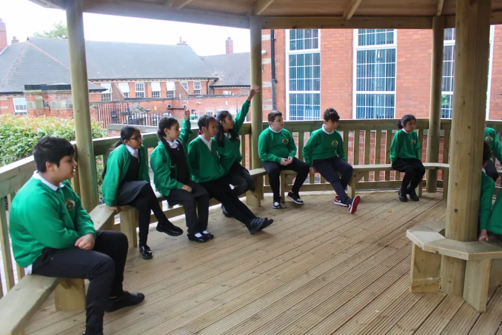 KS2 students using a bespoke gazebo as a form of outdoor classroom seating.