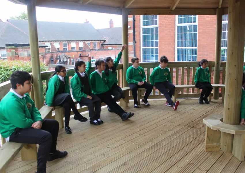 KS2 students using a bespoke gazebo as a form of outdoor classroom seating.