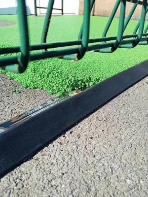 close-up of playground edging trim between tarmac and rubber mulch
