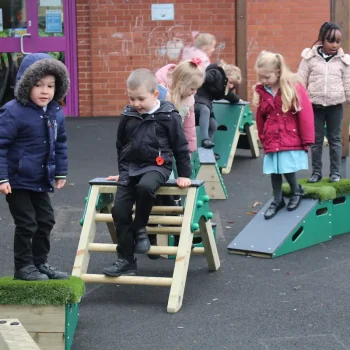 Children clambering over the A Frame ladder and platform ramp