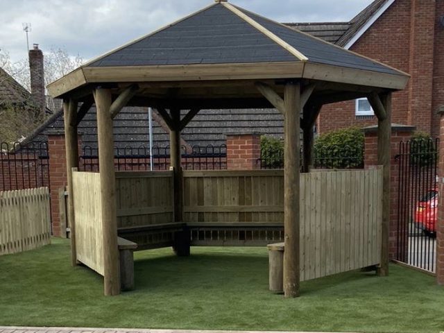 Wooden hexagonal gazebo on artificial grass