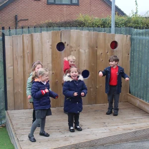 Children dancing on a small wooden stage on a Nottinghamshire school playground