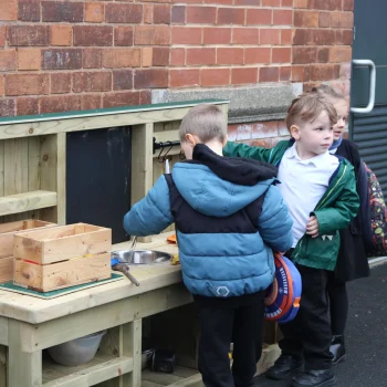 Children playing together with the messy play kitchen
